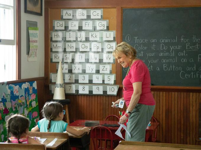 teacher smiling at student to the left